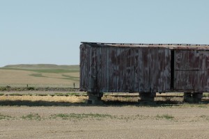 An old wooden box car, converted to a shed, near a grain elevator in Lindsey, MT.